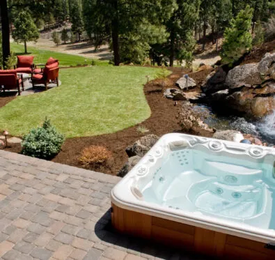 Poolcraft Ltd - Hot tub outside by a rockery water feature