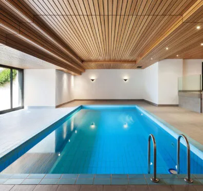 Poolcraft Ltd - Inground inside pool with chrome finishes and natural panel roofing